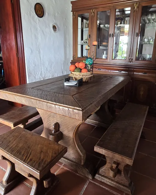 Mesa de comedor de madera maciza con bancas y vajillero antiguo