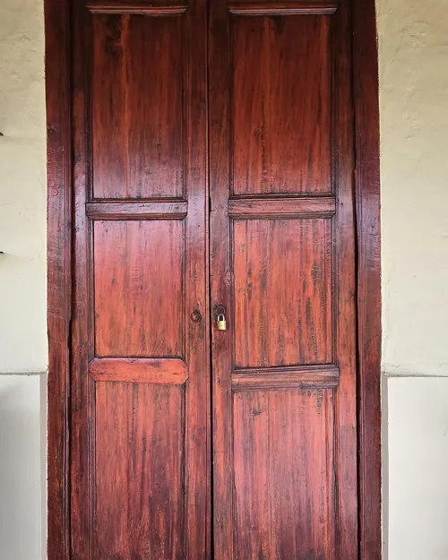 Portón antiguo de madera empotrado en un muro encalado